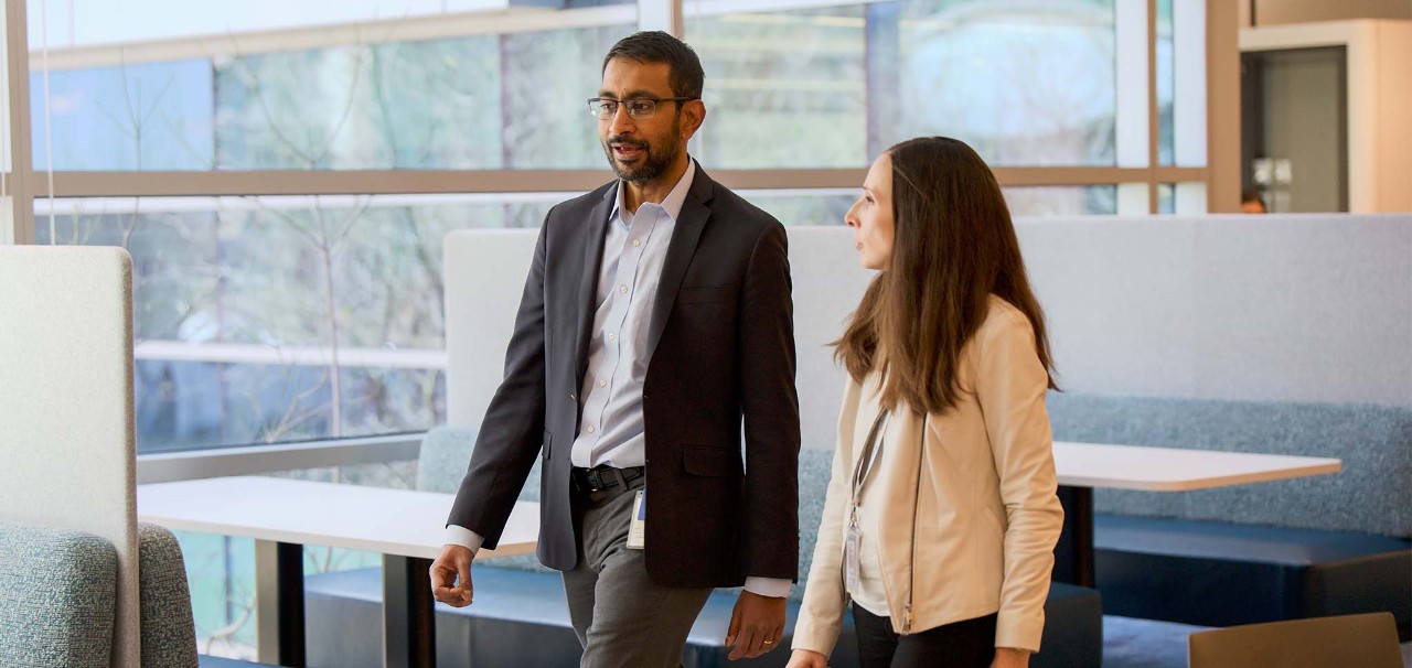 Two employees walking in the office