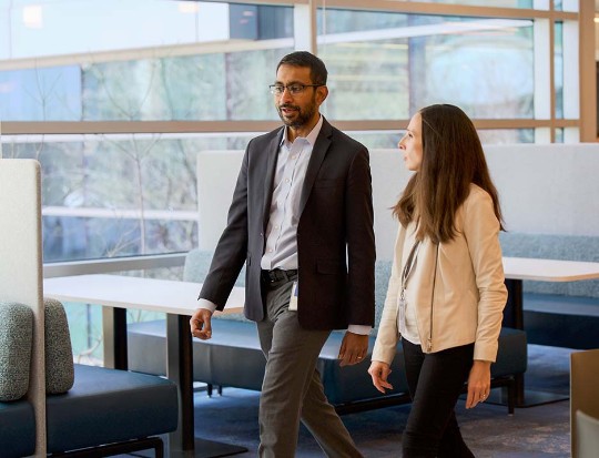 Two employees walking in the office