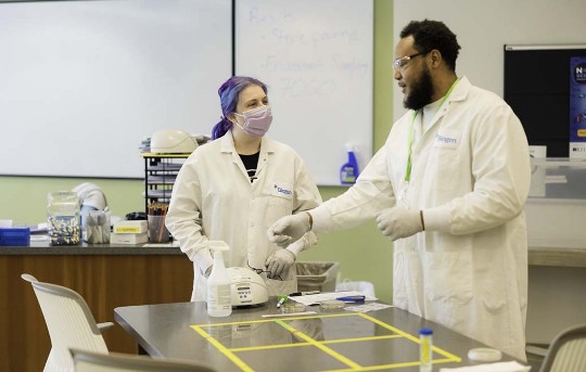 Two employees speaking in the lab
