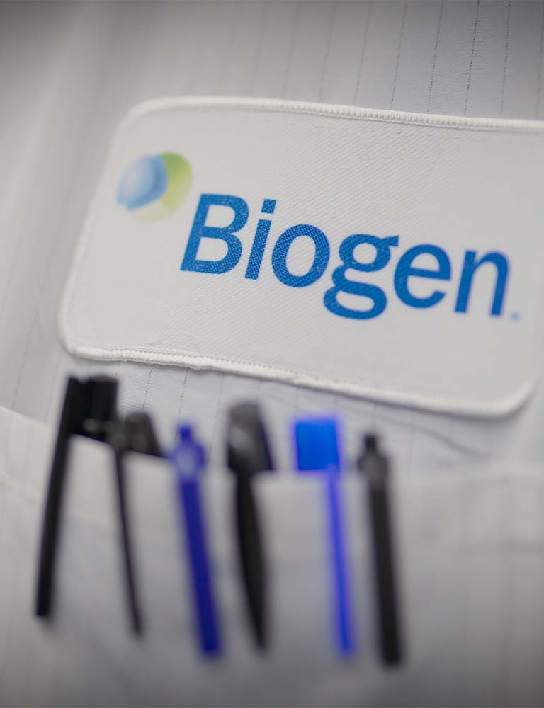Close up of white coat with Biogen jacket and several pens in pocket